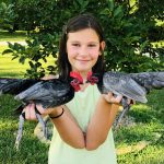 girl holding two chickens