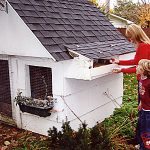 mother and child looking for eggs in hen house