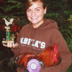 Prize-winning exhibitor showing off her trophy and show chicken