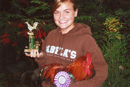 Prize-winning exhibitor showing off her trophy and show chicken