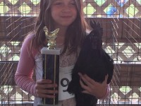 girl holding chicken with trophy