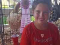 Boy standing in front of prize chicken