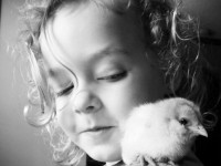 Black and white photo of girl with a chick on shoulder