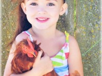 small girl holding red chicken
