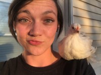 Girl taking a selfie with chicken on shoulder