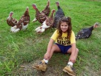 Girl sitting with chickens