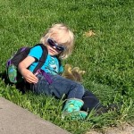 boy laying on ground with baby chicks