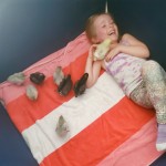 Girl laying on blanket with baby chicks