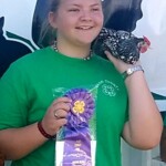 Girls holding ribbon winning chicken
