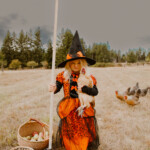 Girl in halloween which costume holding chicken in costume